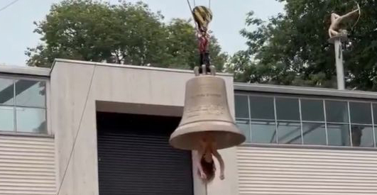 Video: Γυμνή γυναίκα κρεμάστηκε ανάποδα από καμπάνα - Χρησιμοποίησε το σώμα της για να τη χτυπήσει